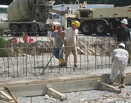 a concrete truck is pouring concrete into a construction site