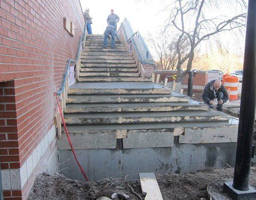 a group of construction workers are working on a set of stairs