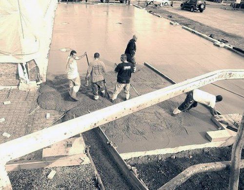 a group of construction workers are working on a concrete floor