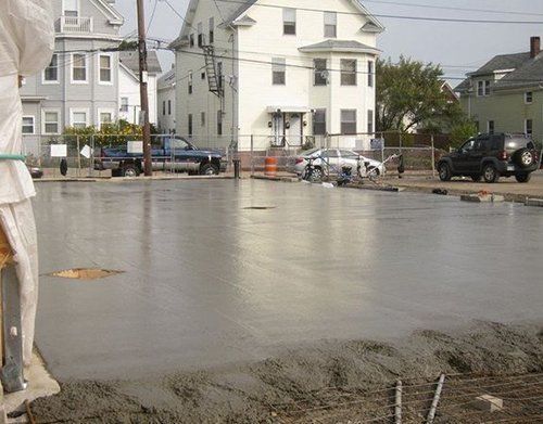a concrete floor is being poured in front of a house