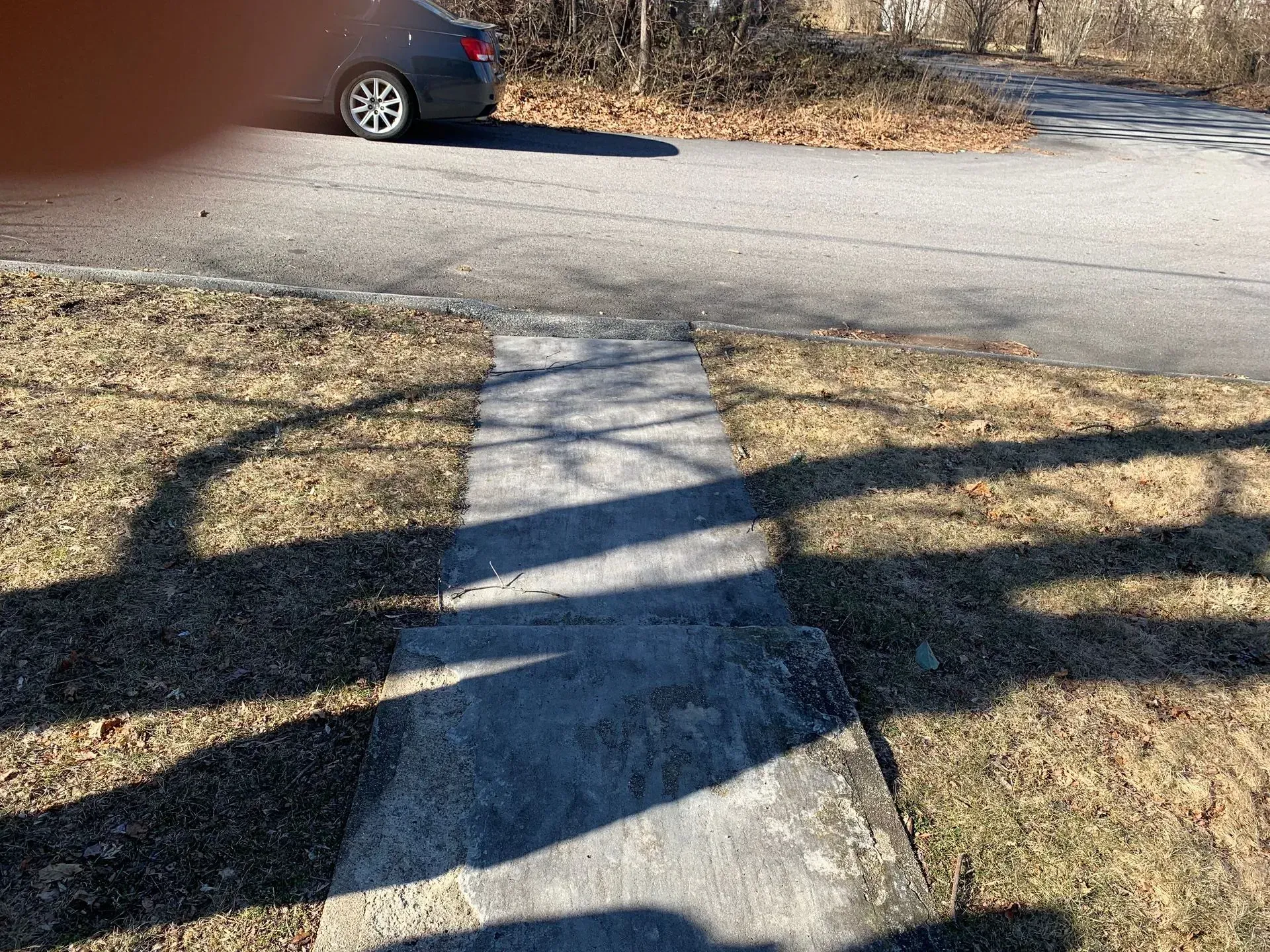 a car is parked on the side of the road next to a sidewalk