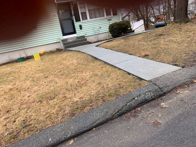 a concrete walkway leading to the front door of a house