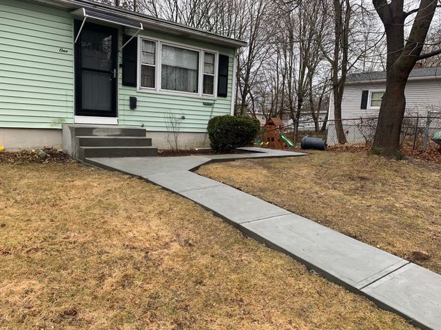 a house with a concrete walkway leading to the front door