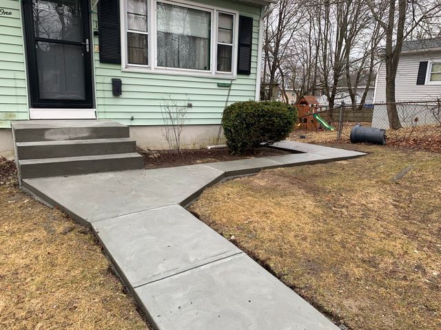 a concrete walkway leading to the front door of a house