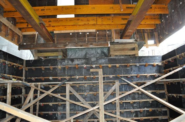 a building under construction with wooden beams hanging from the ceiling