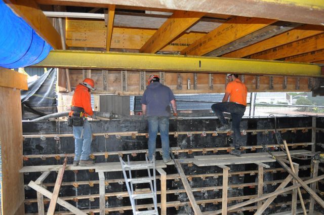 a group of construction workers are working on a wall