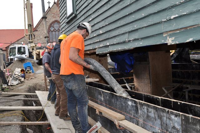a group of construction workers are working on a building