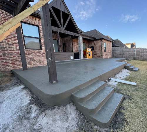 A brick house with a concrete patio in front of it