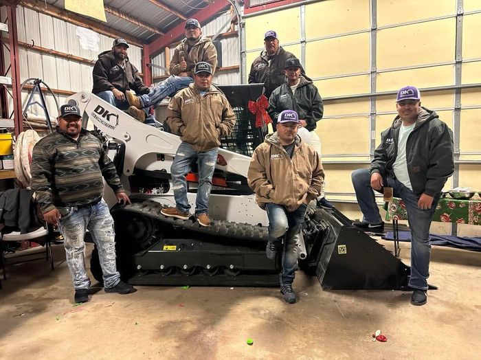 A group of men are posing for a picture in a garage.