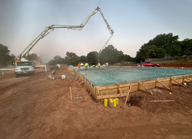 A concrete pump is being used to pour concrete on a construction site.