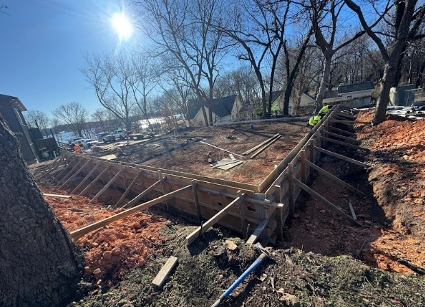 A construction site with a lot of dirt and trees in the background.