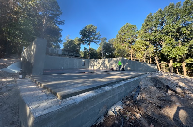 A concrete walkout basement is being built in the middle of a forest.