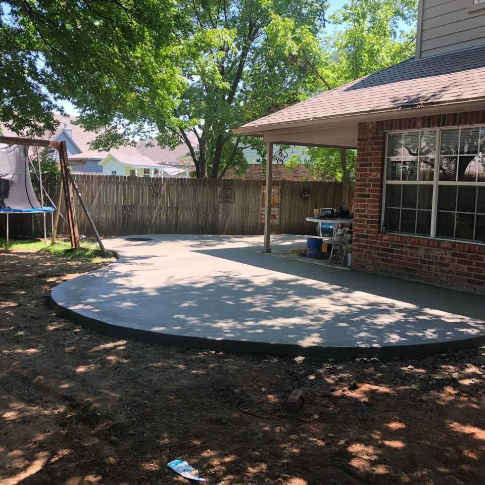 A brick house with a concrete patio in front of it
