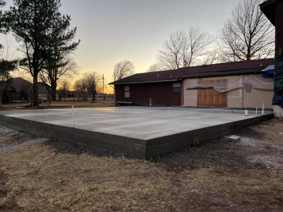 A concrete foundation is being built in front of a house