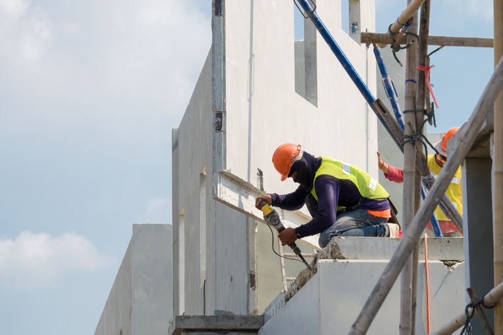 A Group Of Construction Workers Are Working On The Side Of A Building — Pro Cut N Core In Mareeba, QLD