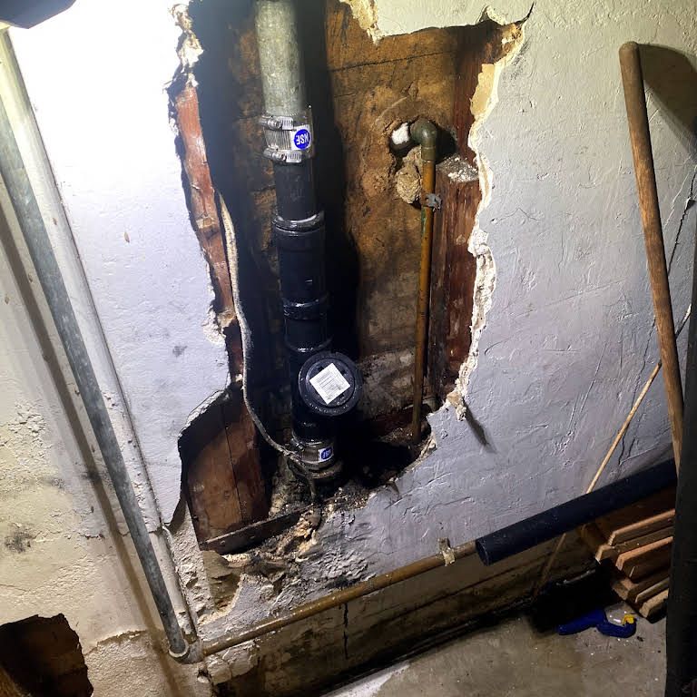 A hole in a wall with a pipe coming out of it