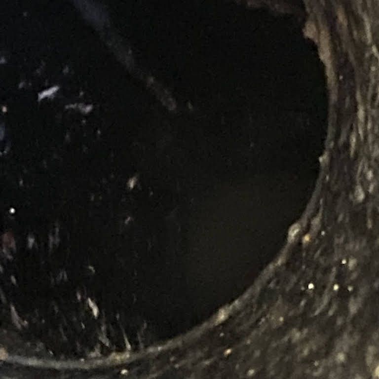 A close up of a black pipe with a hole in it