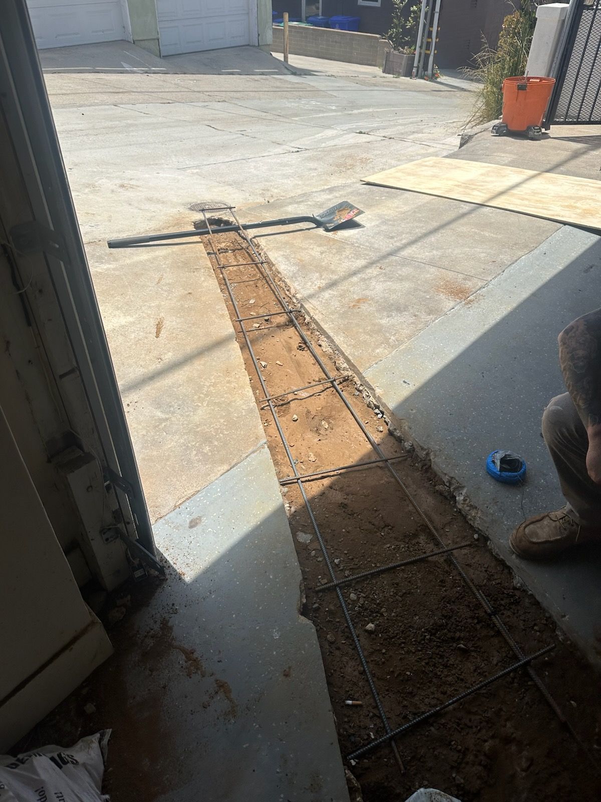 A person is kneeling down in front of a garage door.