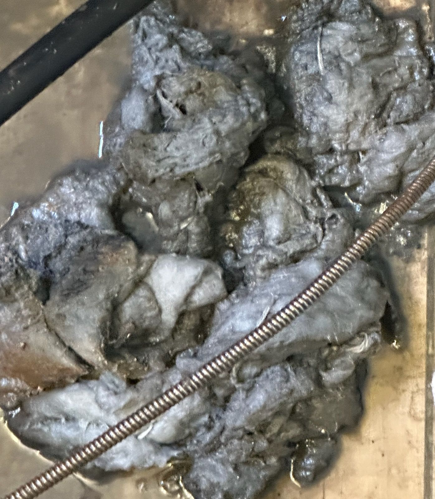 A close up of a pile of dirt and a metal pipe