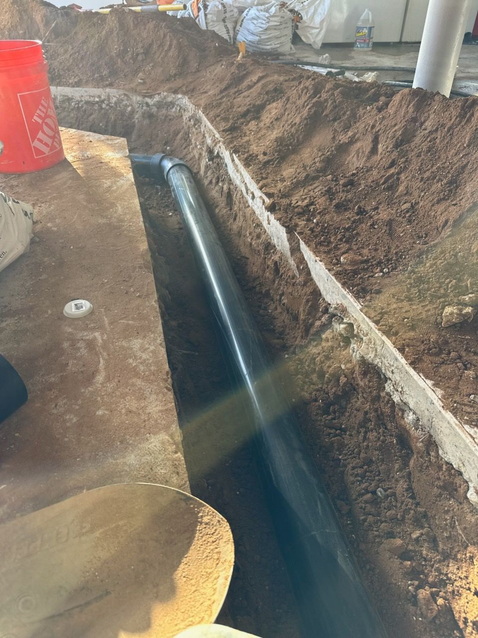 A pipe is being installed in a hole in the ground.