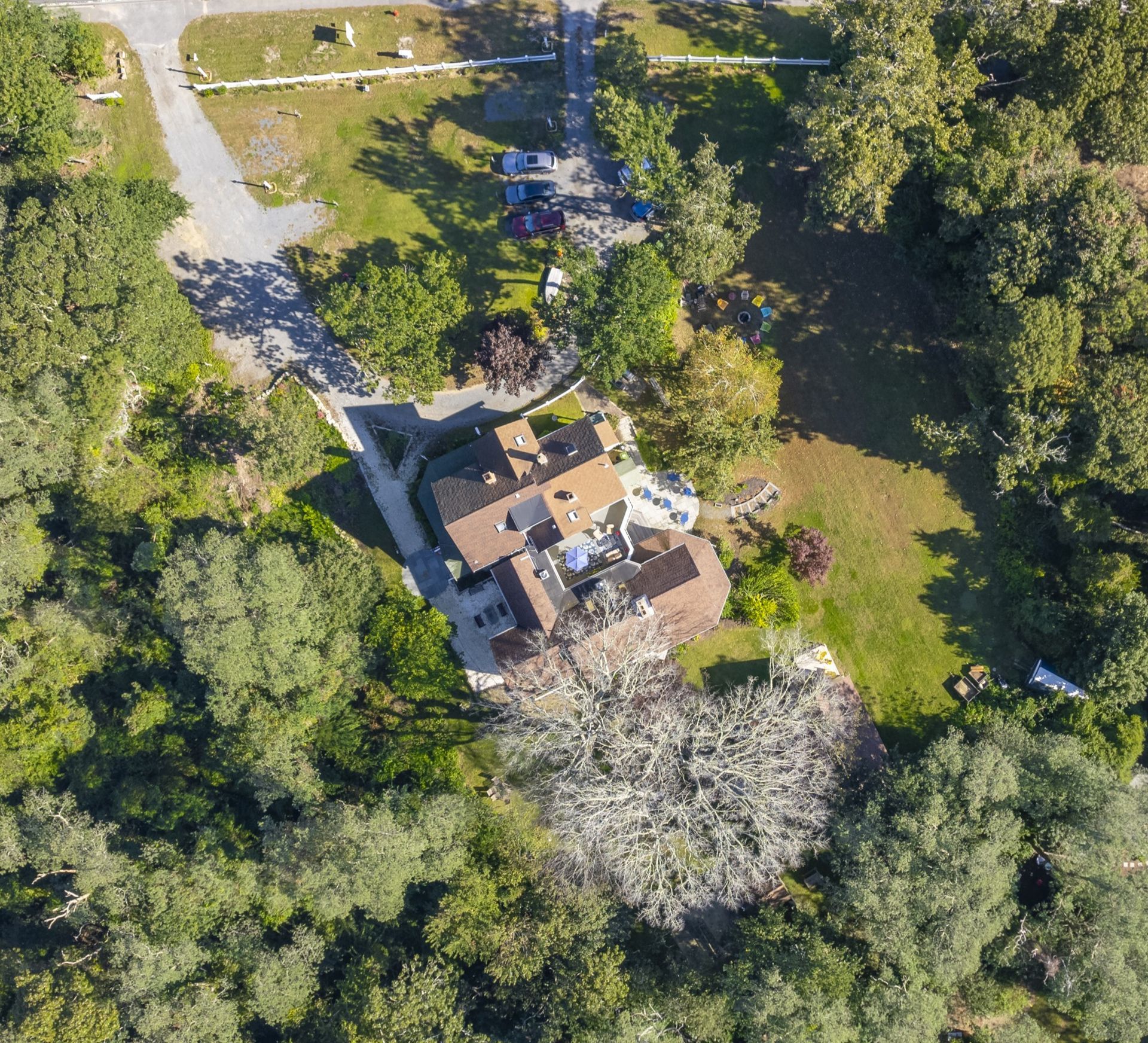 An aerial view of a house surrounded by trees and grass