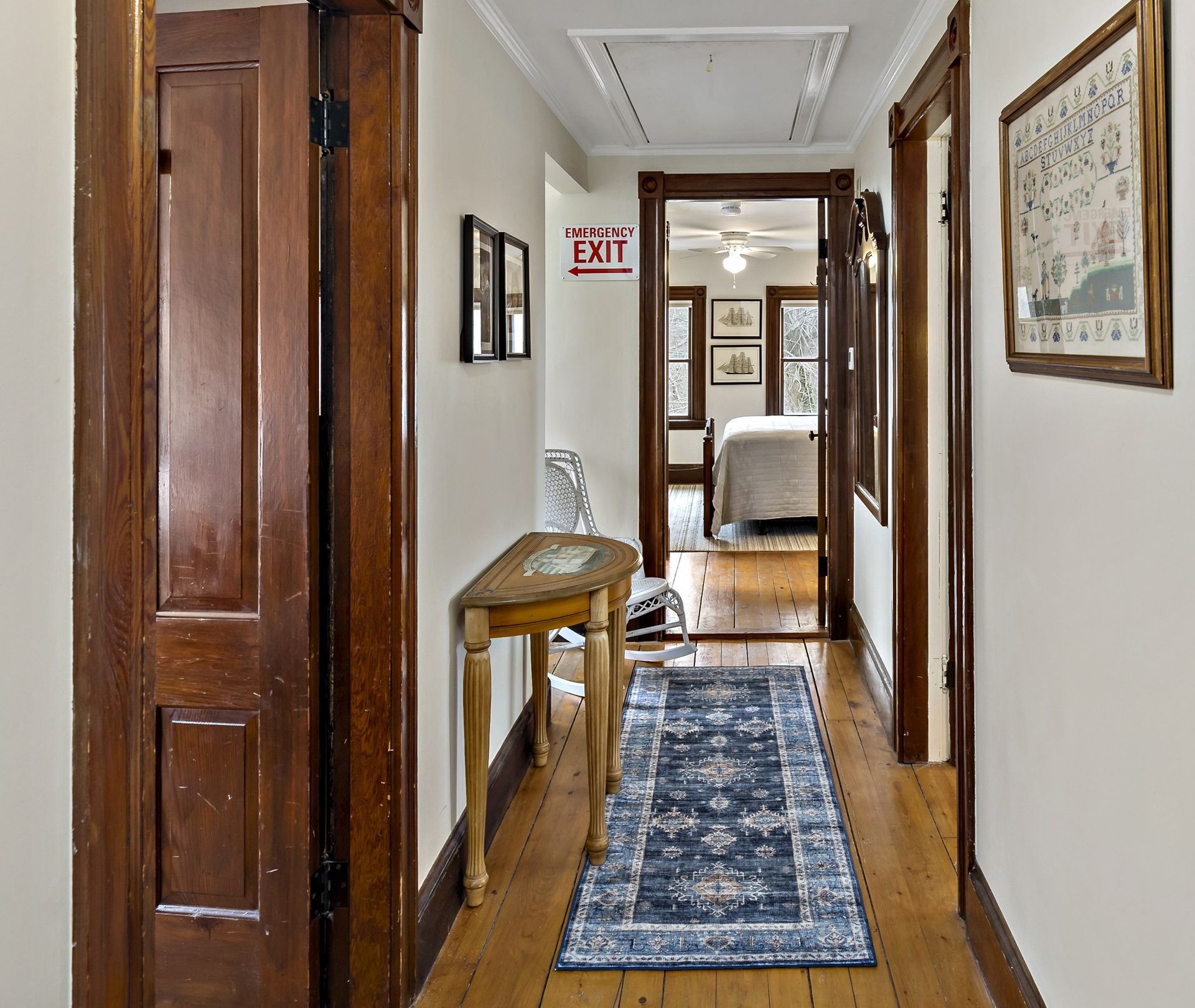 A hallway with a red exit sign on the wall