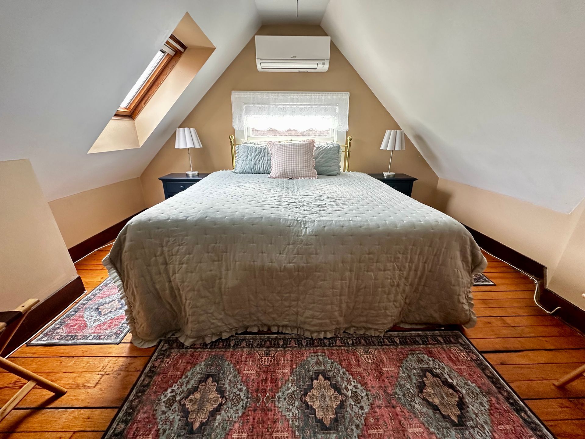 A bedroom with a king and a skylight