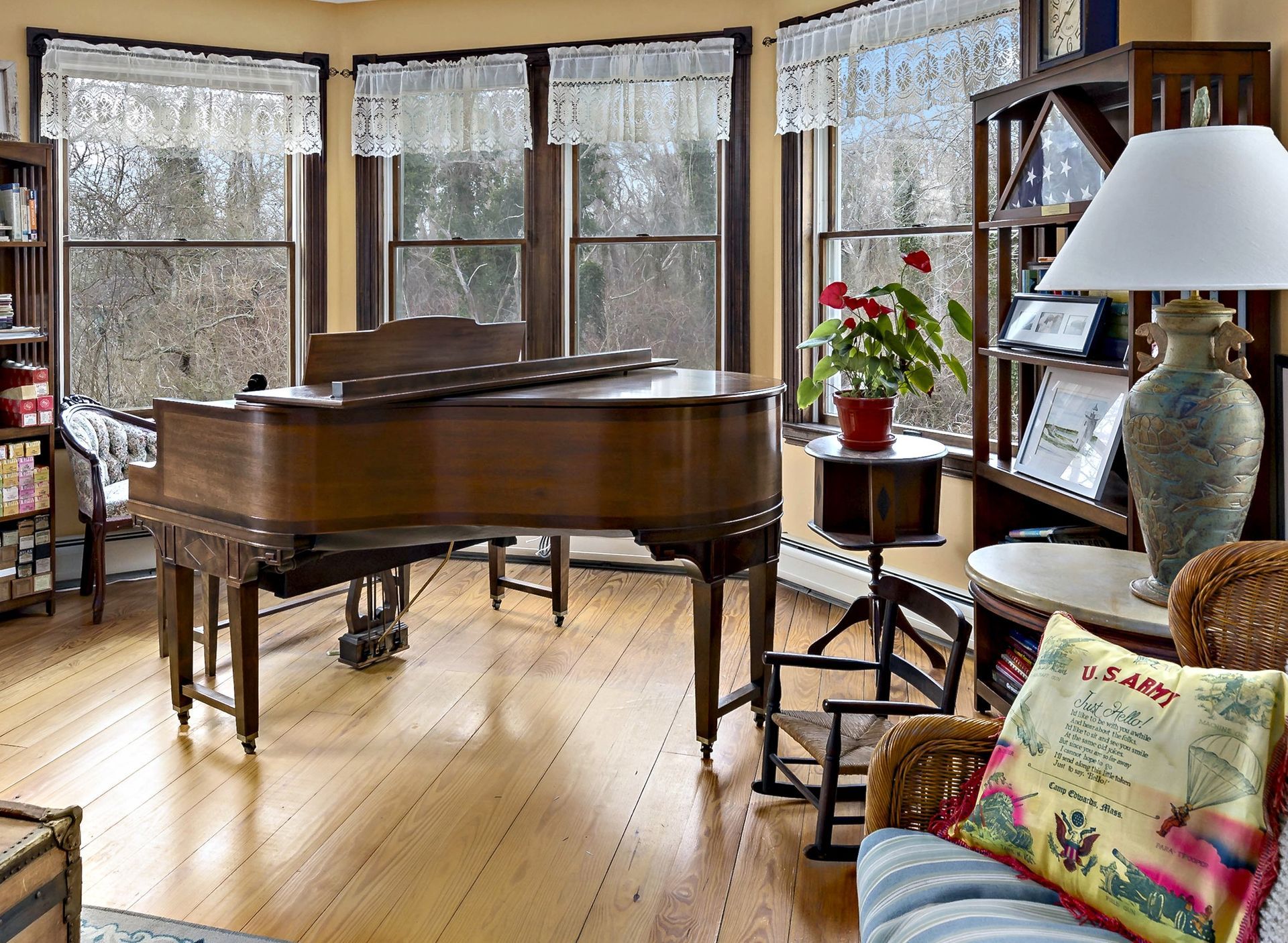 A living room with a grand piano and a lamp