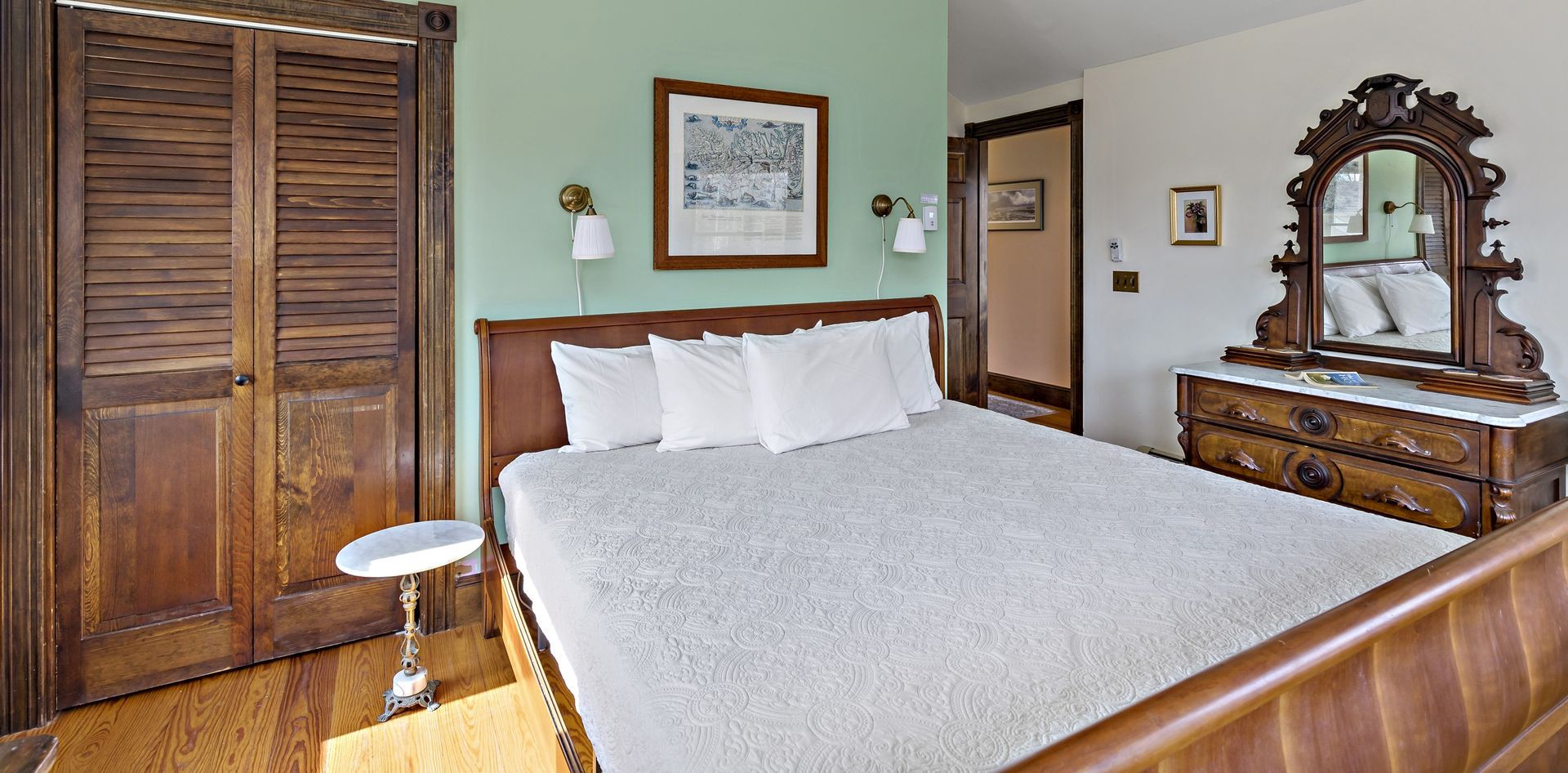 A bedroom with a bed , dresser and mirror