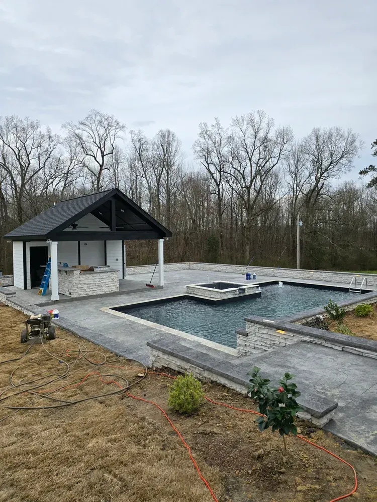 A large swimming pool is being built in the backyard of a house.