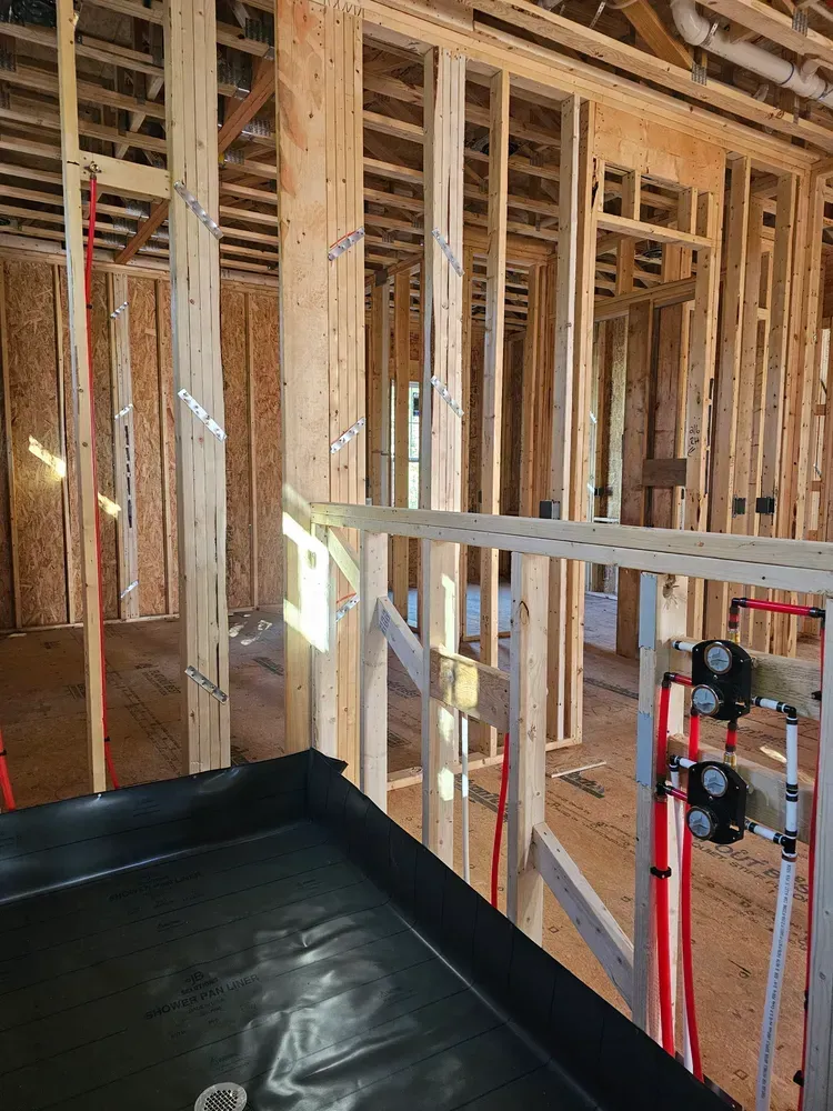 The inside of a house under construction with a ladder in the foreground.
