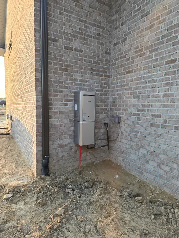A brick building with a heater installed on the side of it.