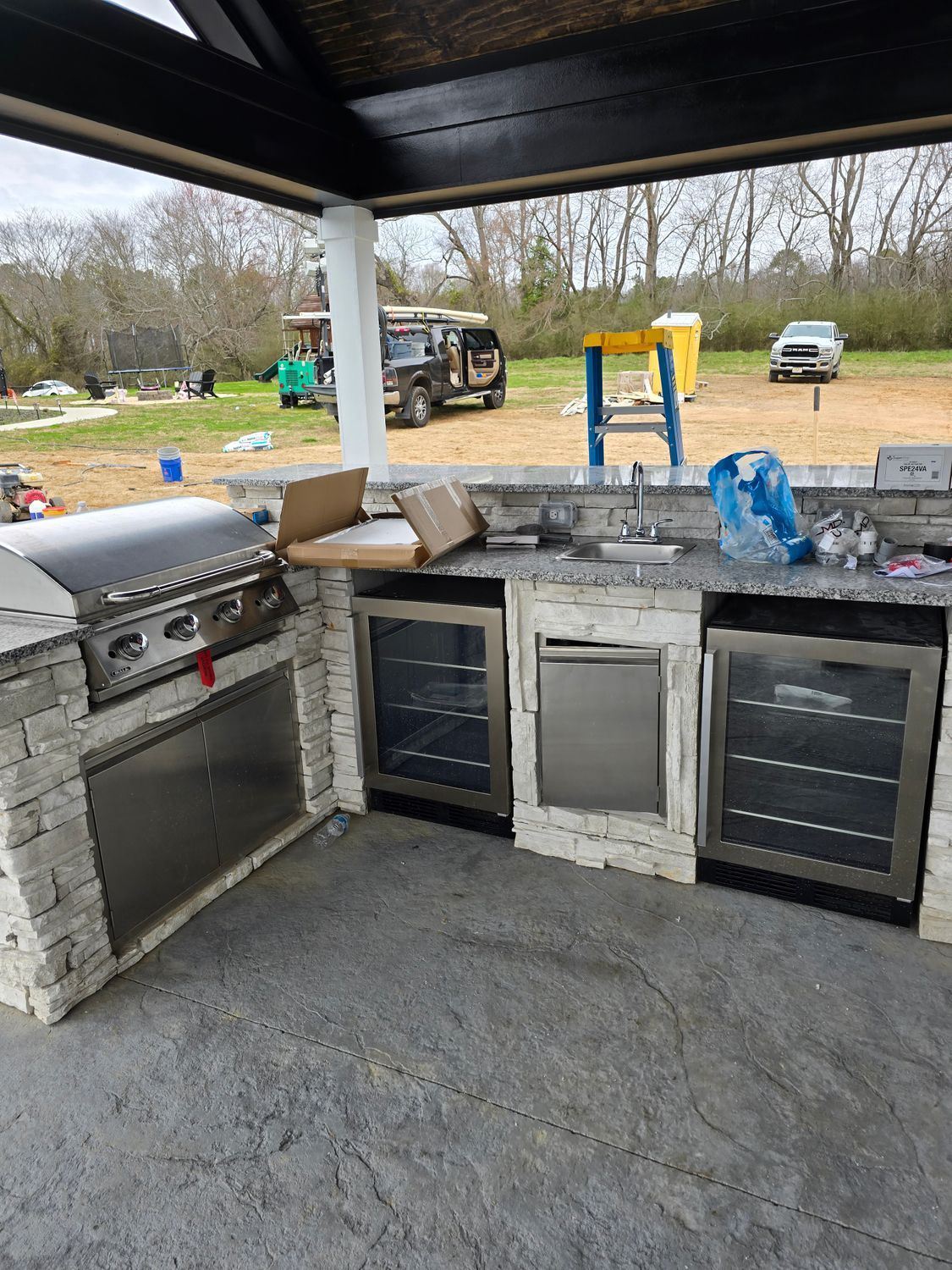 A kitchen with a grill , refrigerator , sink , and dishwasher.