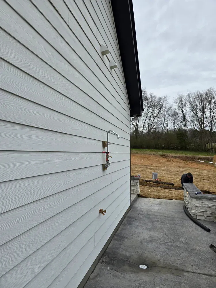 A white house with a shower on the side of it
