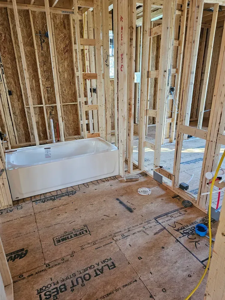 A bathroom in a house under construction with a bathtub.