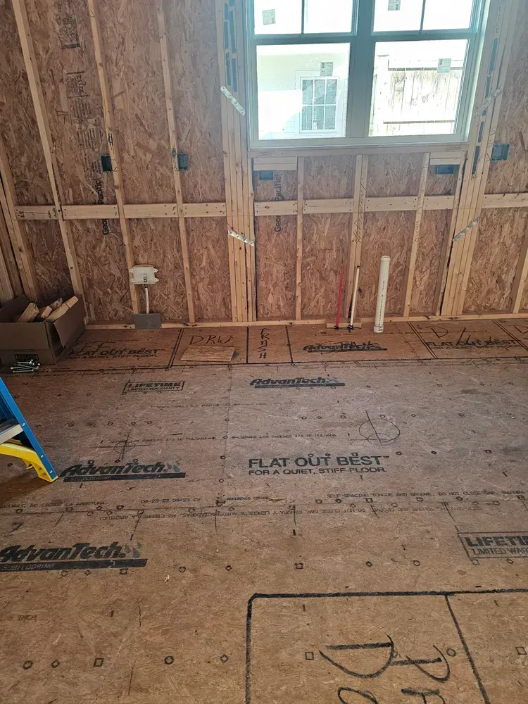 A room in a house under construction with a ladder on the floor.