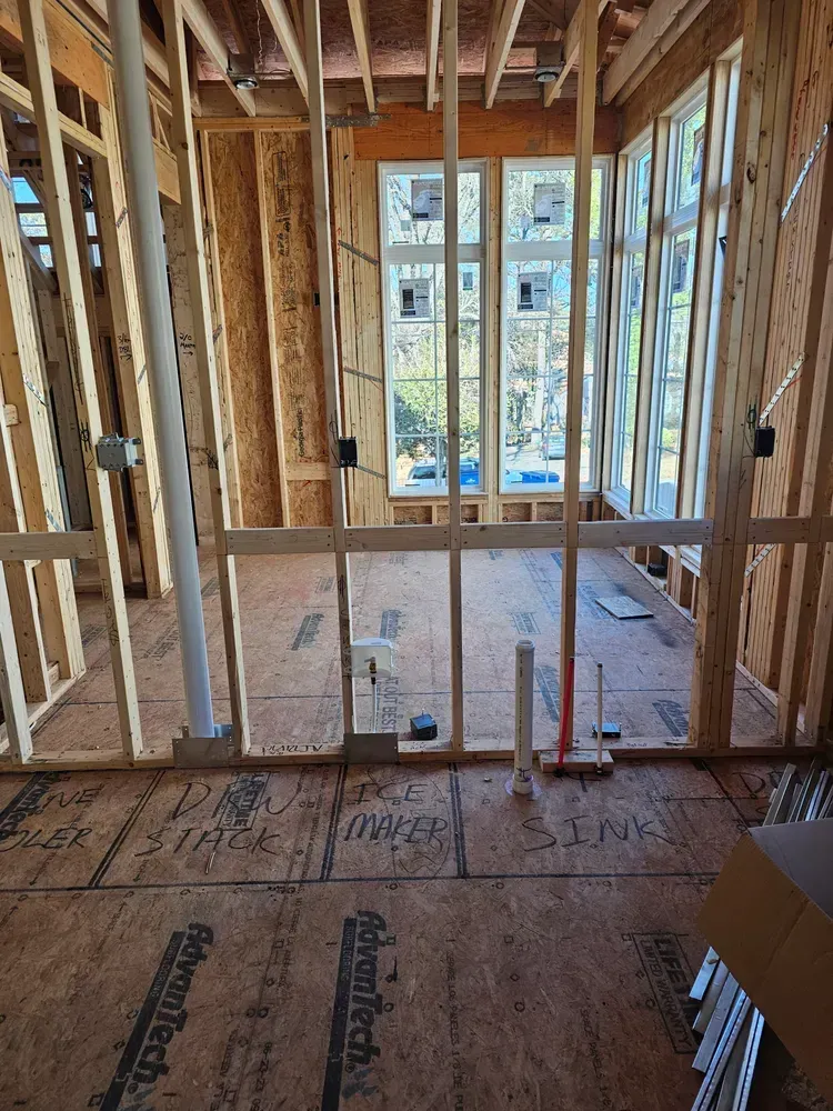 A room in a house under construction with a lot of windows.