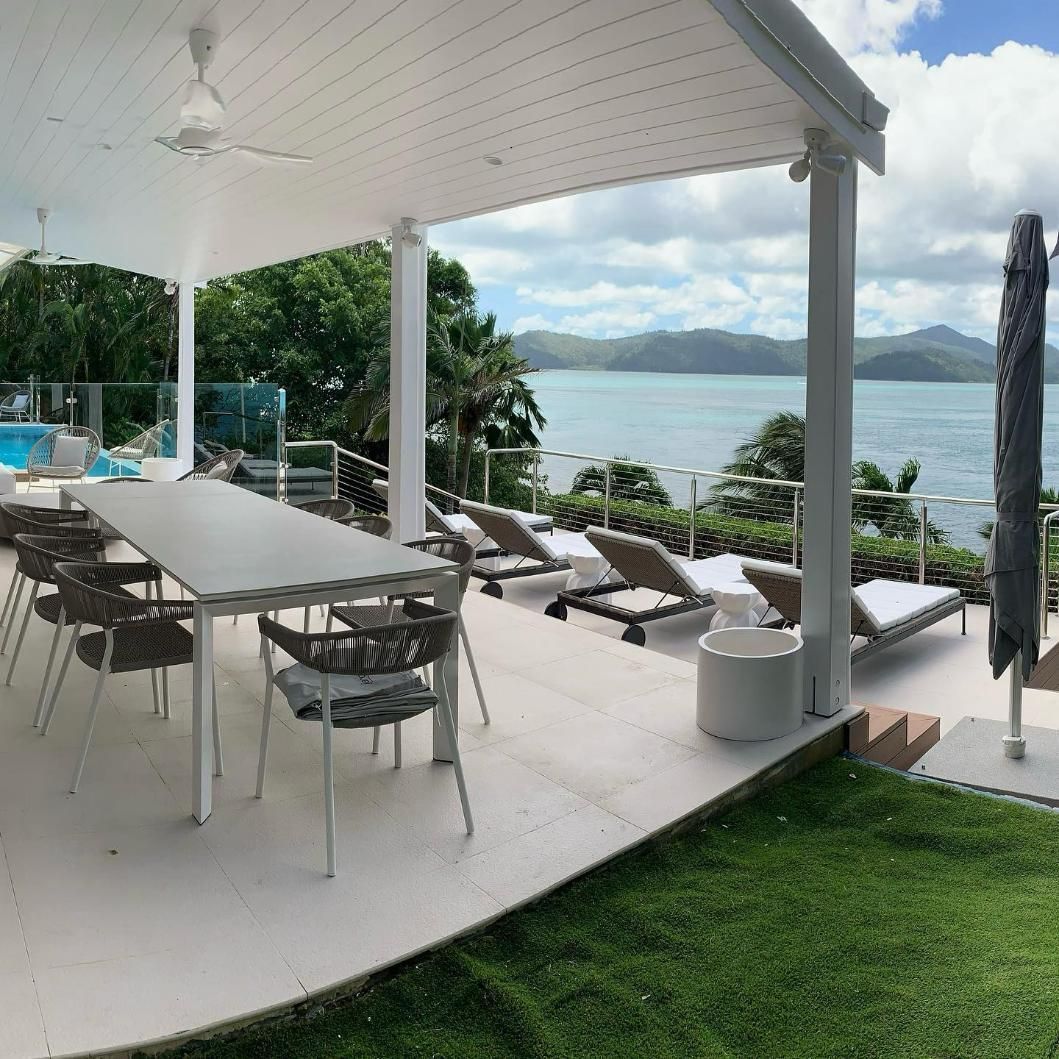A Patio with A Table and Chairs Overlooking the Ocean — Coral Coast Building & Management in Cannon Valley, QLD
