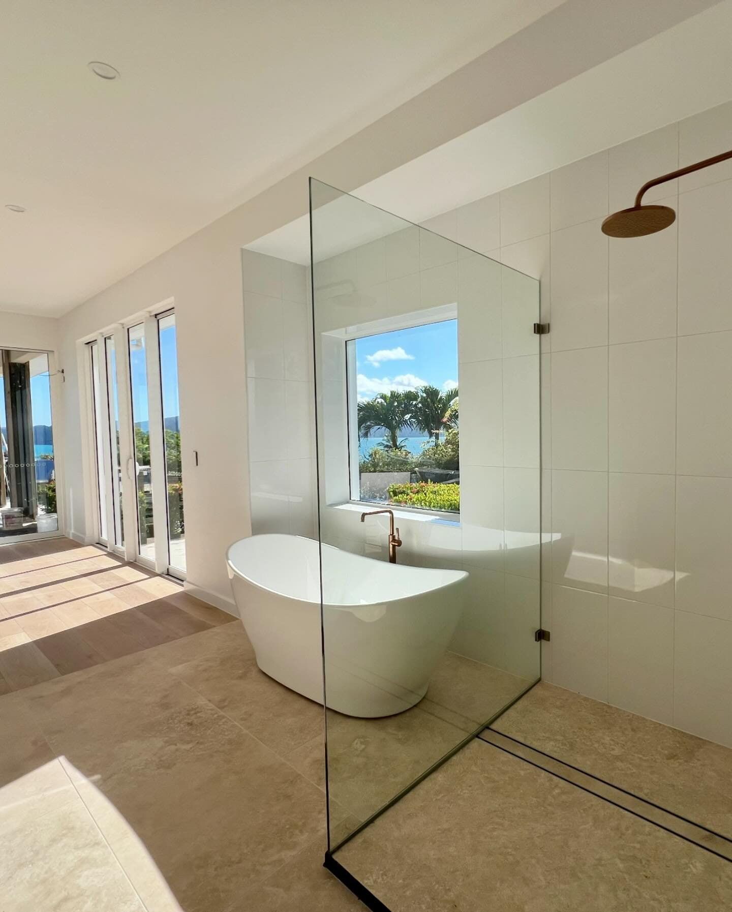 A Bathroom With a Bathtub and a Shower With a View of the Ocean — Coral Coast Building & Management in Cannon Valley, QLD