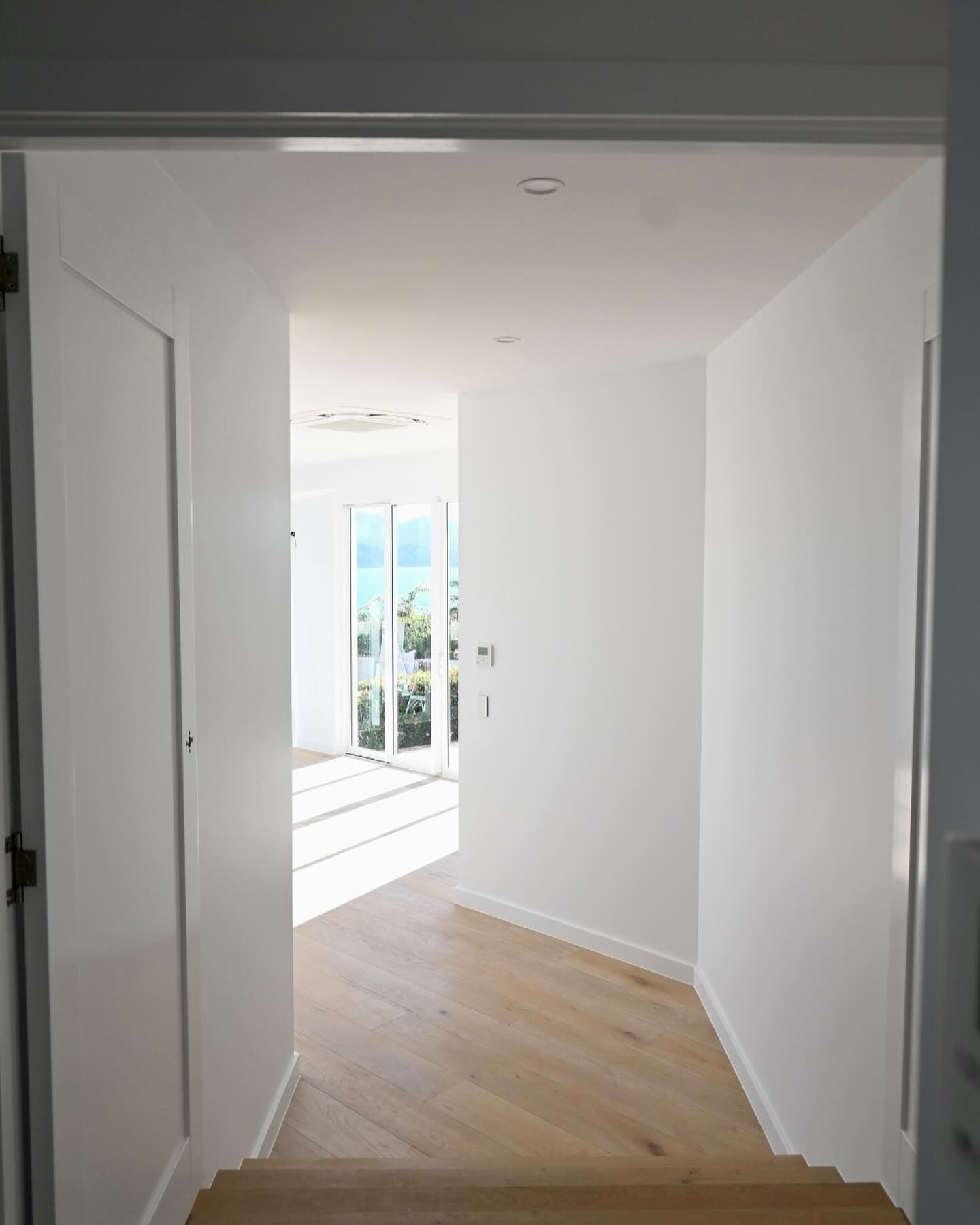 A Hallway With a Wooden Floor and White Walls — Coral Coast Building & Management in Hamilton Island, QLD
