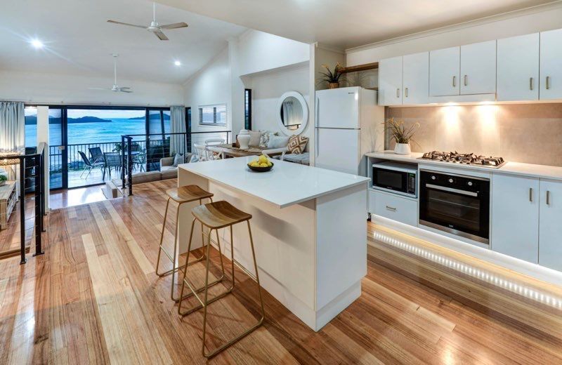 A Kitchen With a Large Island and Stools and a View of the Ocean — Coral Coast Building & Management in Cannon Valley, QLD
