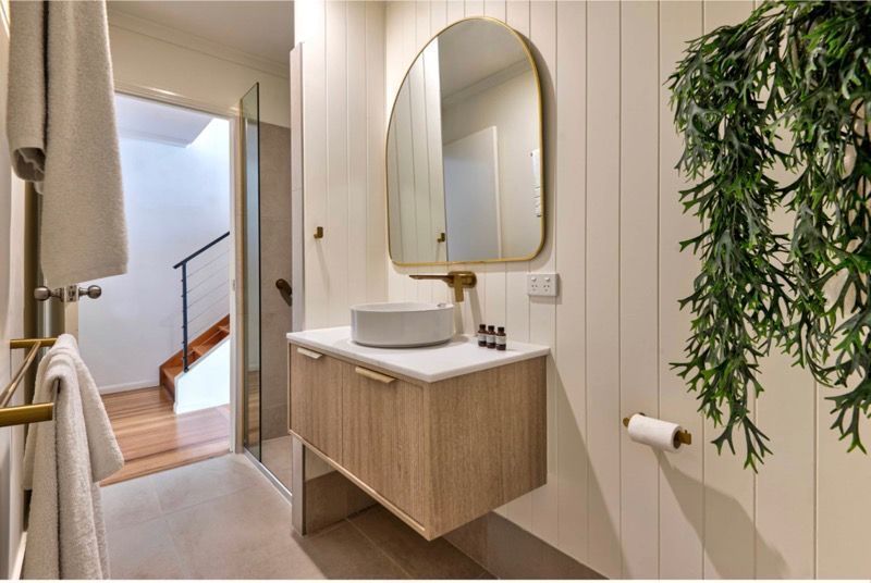 A Bathroom With a Sink , Mirror and Towel Rack — Coral Coast Building & Management in Cannon Valley, QLD