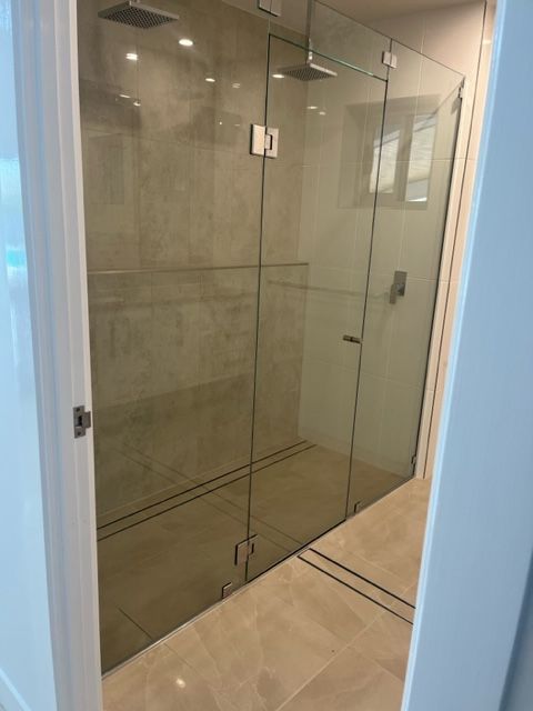A Bathroom With a Walk in Shower With a Glass Door — Coral Coast Building & Management in Cannon Valley, QLD
