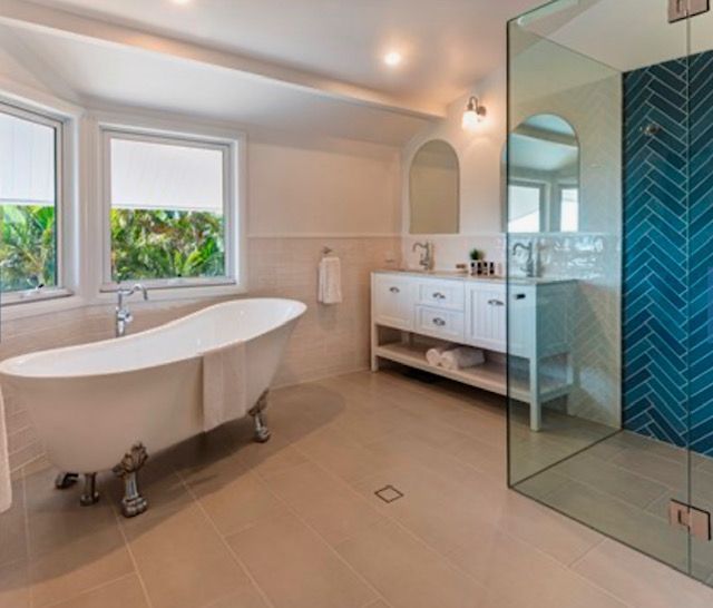 A Bathroom With a Bathtub , Sink , Mirror and Walk in Shower — Coral Coast Building & Management in Cannon Valley, QLD