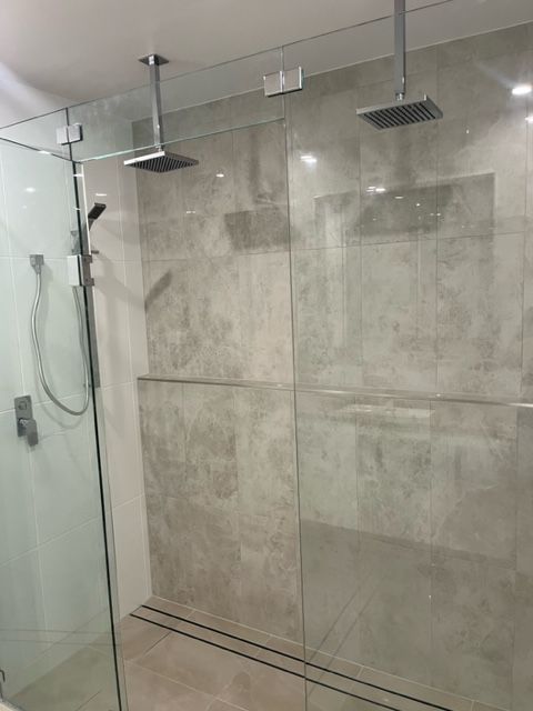 A Bathroom With a Walk in Shower and Two Shower Heads — Coral Coast Building & Management in Cannon Valley, QLD