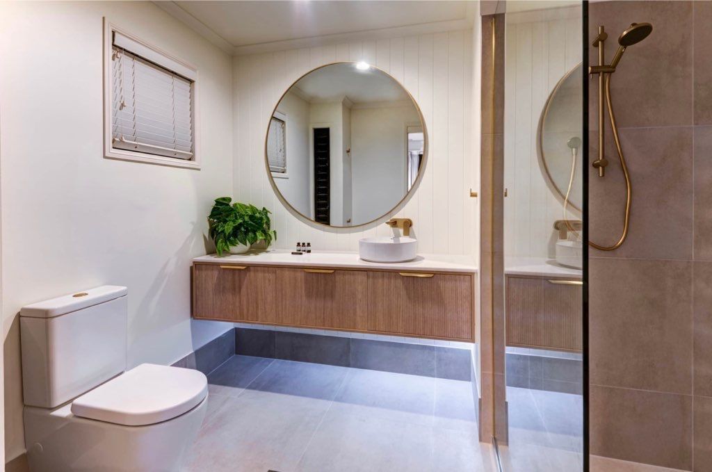 A Bathroom With a Toilet , Sink and Shower — Coral Coast Building & Management in Cannon Valley, QLD