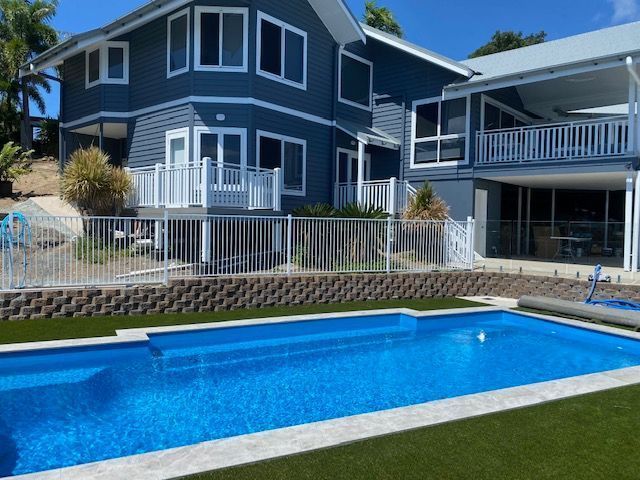 A Large House With a Large Swimming Pool in Front of It — Coral Coast Building & Management in Cannon Valley, QLD