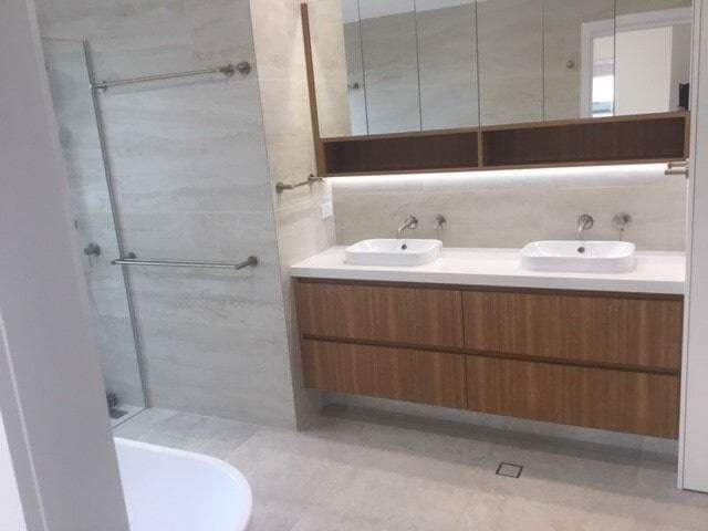 A Bathroom With Two Sinks and a Bathtub — Coral Coast Building & Management in Cannon Valley, QLD