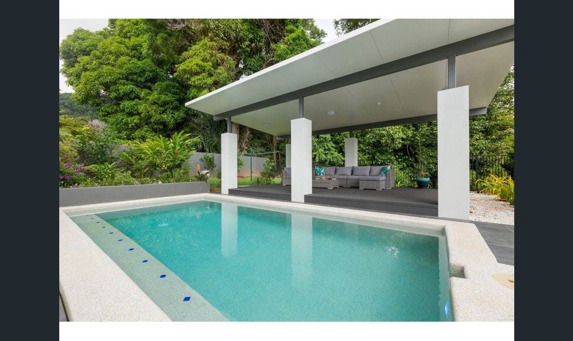 A Large Swimming Pool is Surrounded by Trees and a Gazebo — Coral Coast Building & Management in Cannon Valley, QLD
