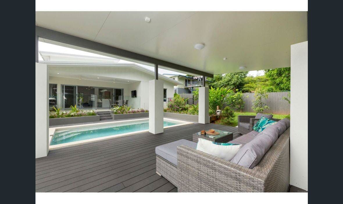A Patio With a Couch and a Pool in the Background — Coral Coast Building & Management in Cannon Valley, QLD